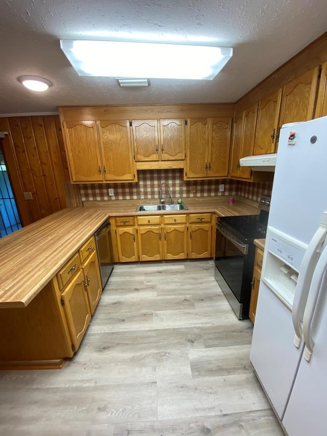 kitchen with tasteful backsplash, light hardwood / wood-style flooring, black appliances, and sink