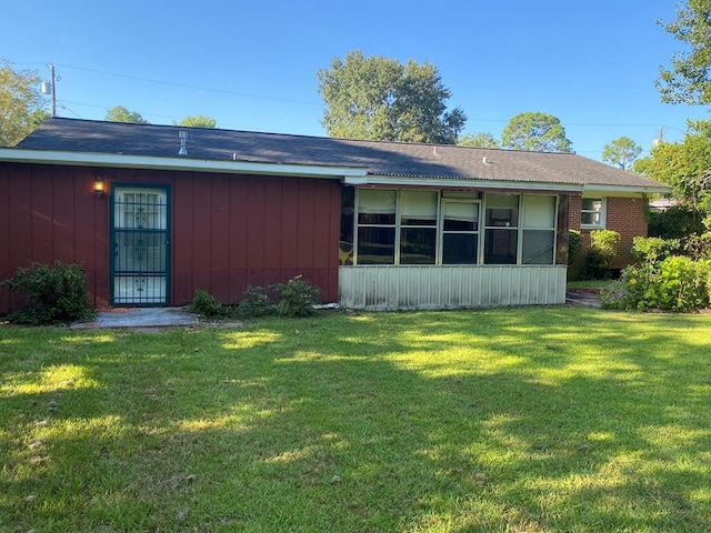 back of property featuring a lawn