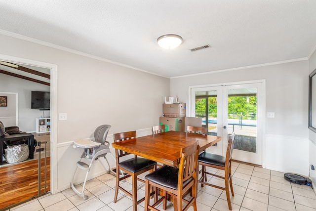 dining space featuring french doors, a textured ceiling, light tile patterned floors, and lofted ceiling