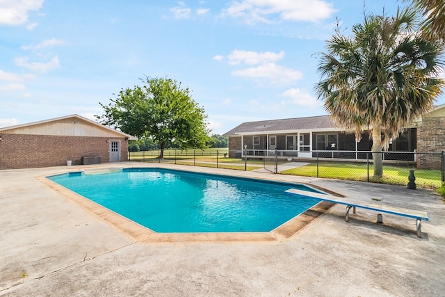 view of swimming pool with central AC unit, a diving board, a patio area, and a sunroom