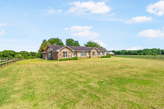 view of front of house with a rural view and a front lawn