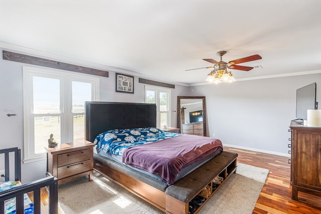 bedroom featuring hardwood / wood-style flooring, ceiling fan, and ornamental molding