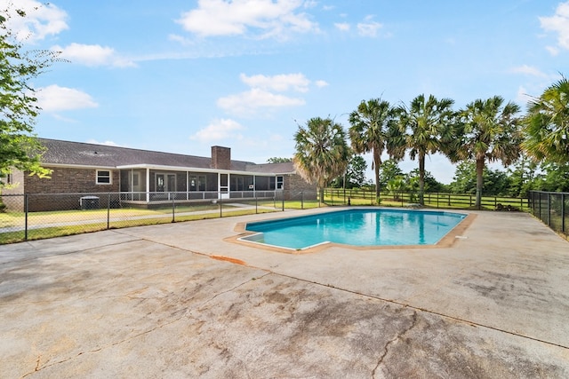 view of swimming pool featuring a patio area and a sunroom