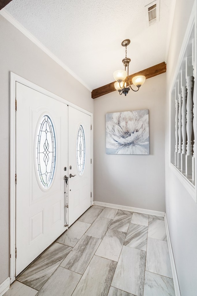 foyer featuring beam ceiling, ornamental molding, a textured ceiling, and an inviting chandelier