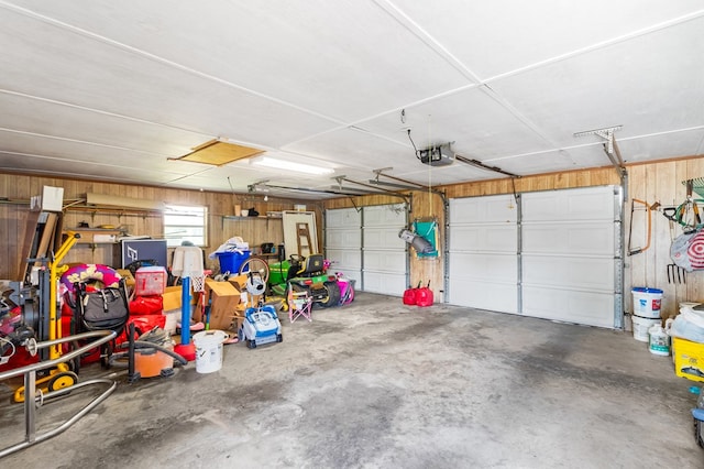 garage featuring wooden walls and a garage door opener