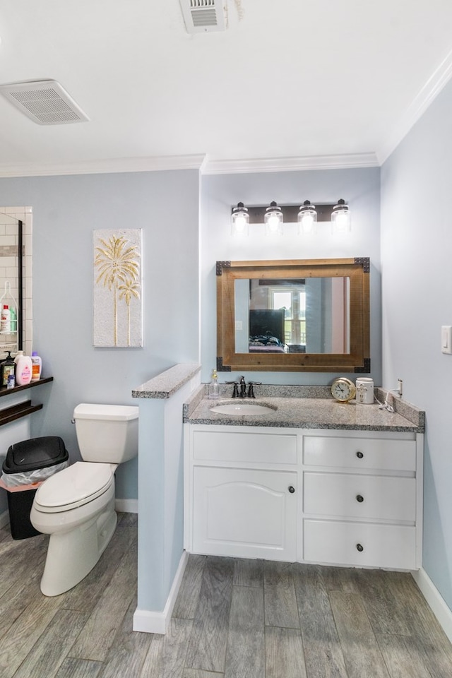 bathroom with hardwood / wood-style floors, vanity, toilet, and crown molding