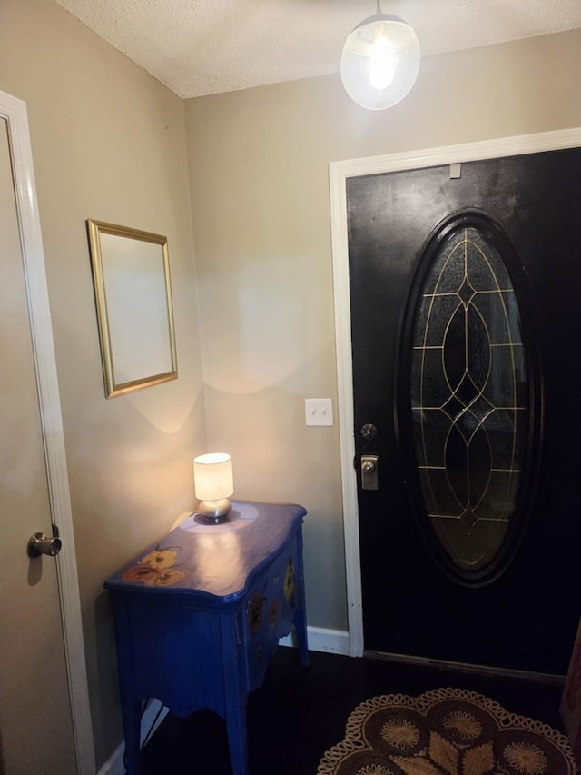 entryway with baseboards and a textured ceiling