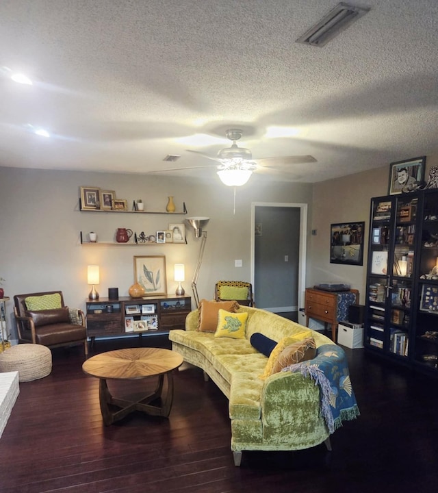 living area with ceiling fan, visible vents, a textured ceiling, and wood finished floors