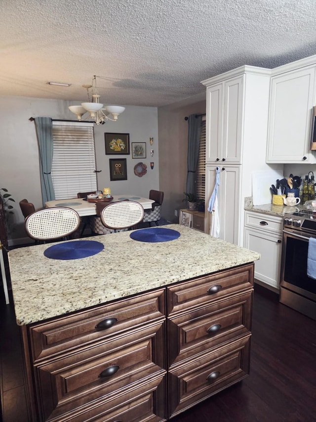 kitchen featuring an inviting chandelier, appliances with stainless steel finishes, dark wood-style floors, and white cabinetry