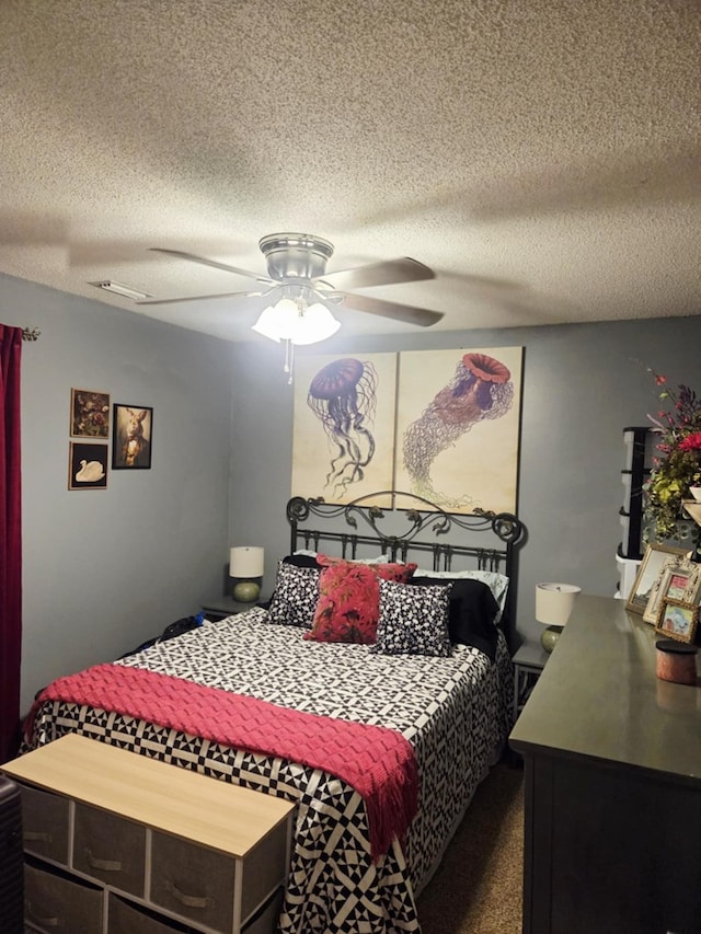 bedroom featuring a textured ceiling, ceiling fan, and dark colored carpet