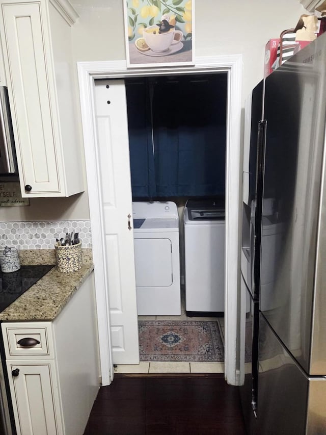 washroom featuring cabinet space, independent washer and dryer, and tile patterned floors