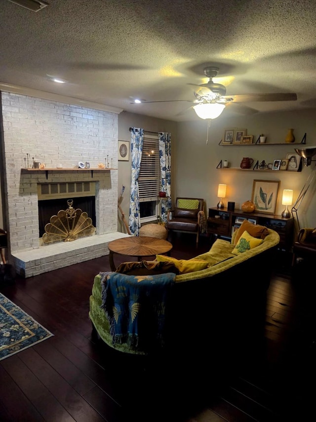 living room featuring a fireplace, a textured ceiling, ceiling fan, and hardwood / wood-style flooring