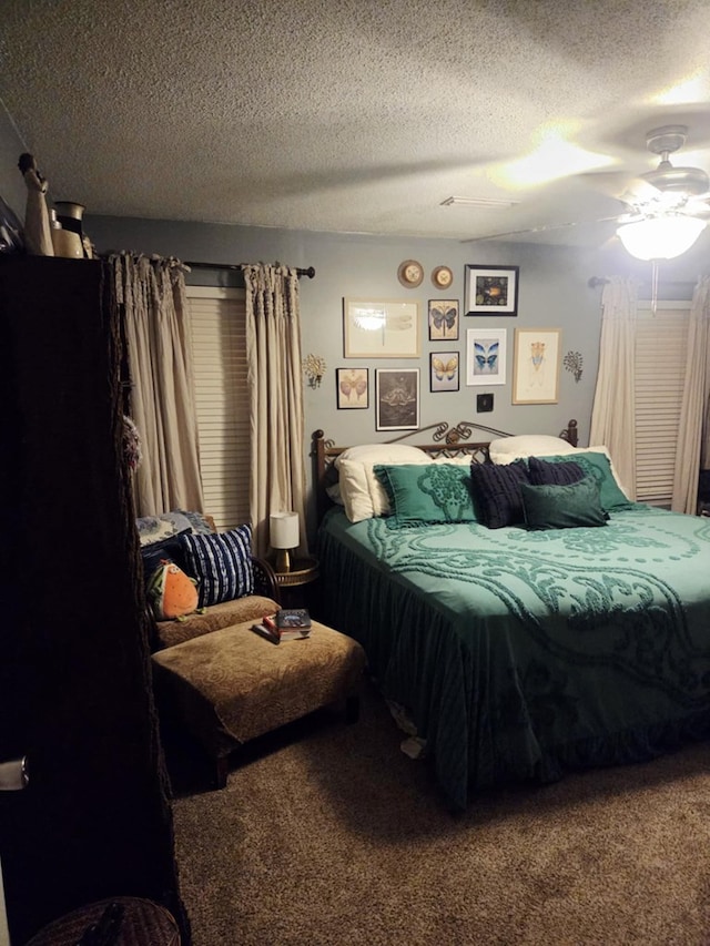 carpeted bedroom featuring a textured ceiling and ceiling fan