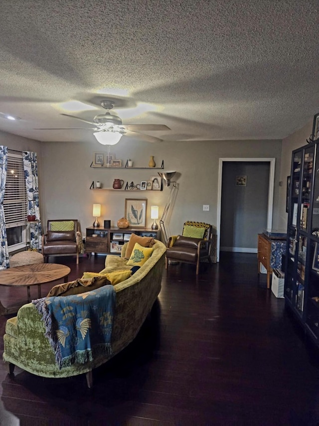 living room with a ceiling fan, wood finished floors, and a textured ceiling