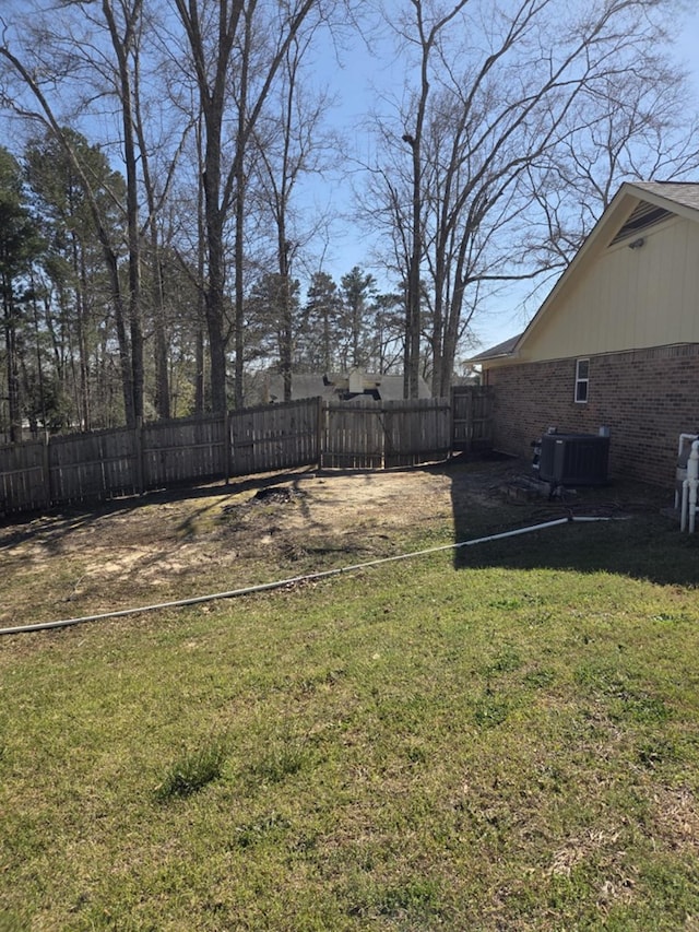 view of yard featuring central air condition unit and fence