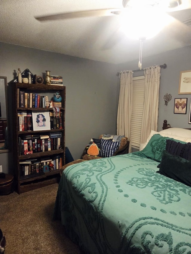 carpeted bedroom with a textured ceiling and a ceiling fan