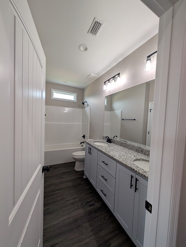 12589 Fortner St, Newton, AL 36352 - bathroom featuring double vanity, toilet, wood finished floors, bathtub / shower combination, and recessed lighting