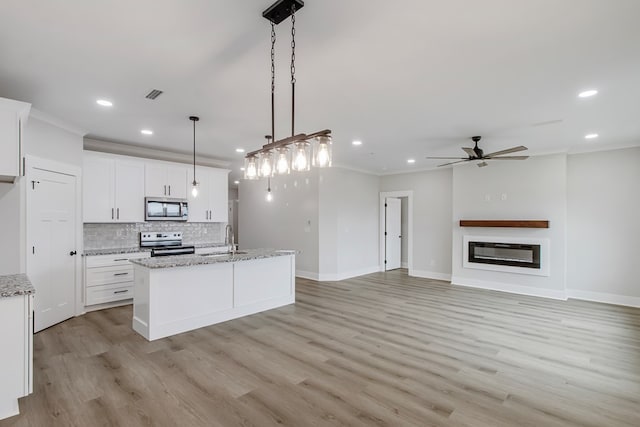 kitchen featuring stainless steel appliances, sink, hanging light fixtures, and white cabinets