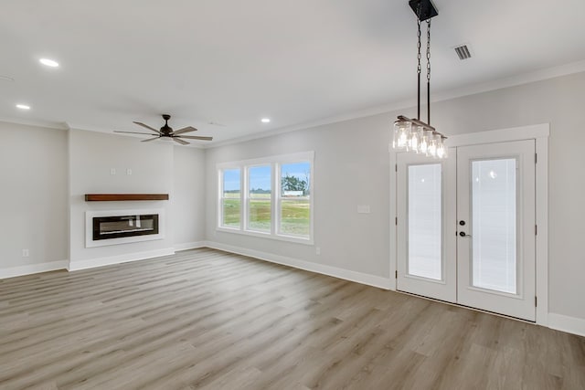 unfurnished living room featuring ornamental molding, ceiling fan, light wood-type flooring, and french doors