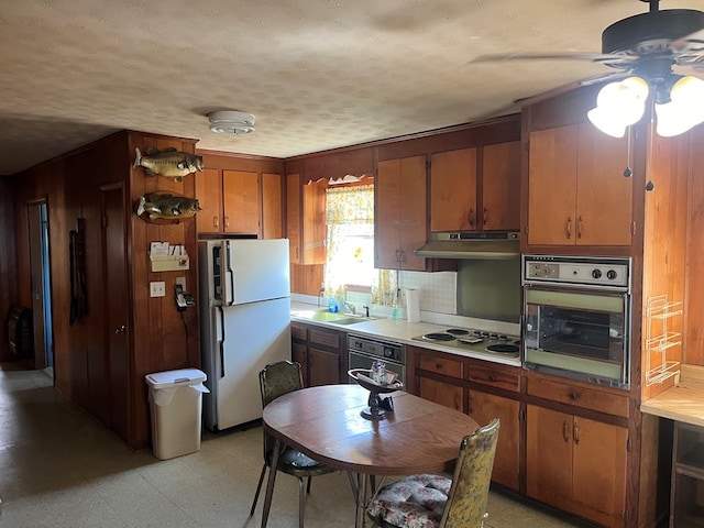 kitchen with white appliances, sink, and a textured ceiling