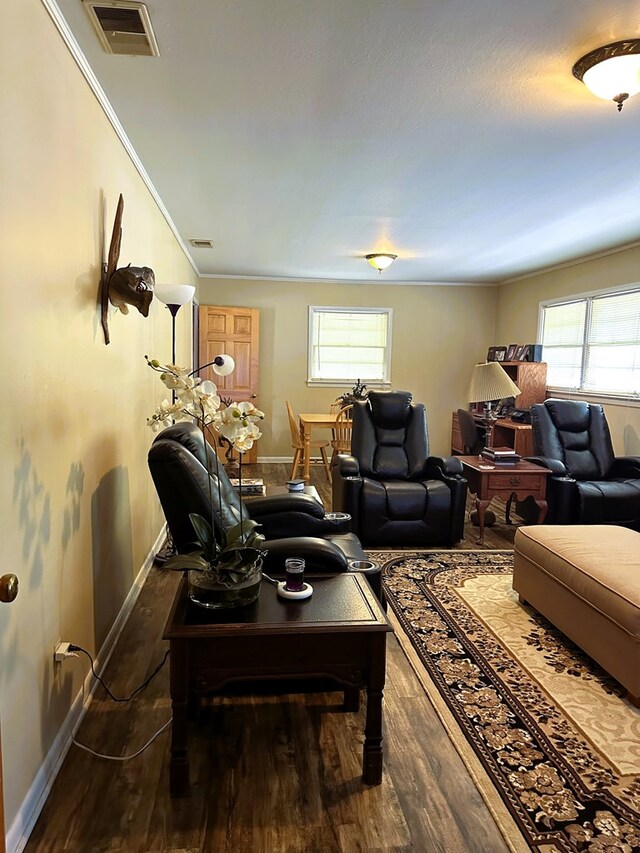 living room featuring a healthy amount of sunlight, crown molding, and dark wood-type flooring