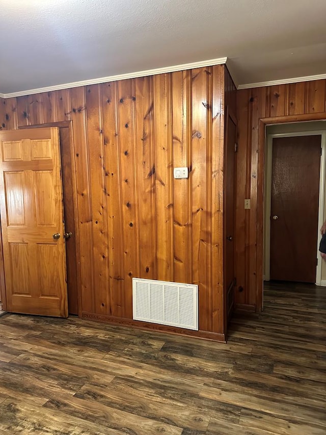 interior space featuring crown molding, dark wood-type flooring, and wood walls