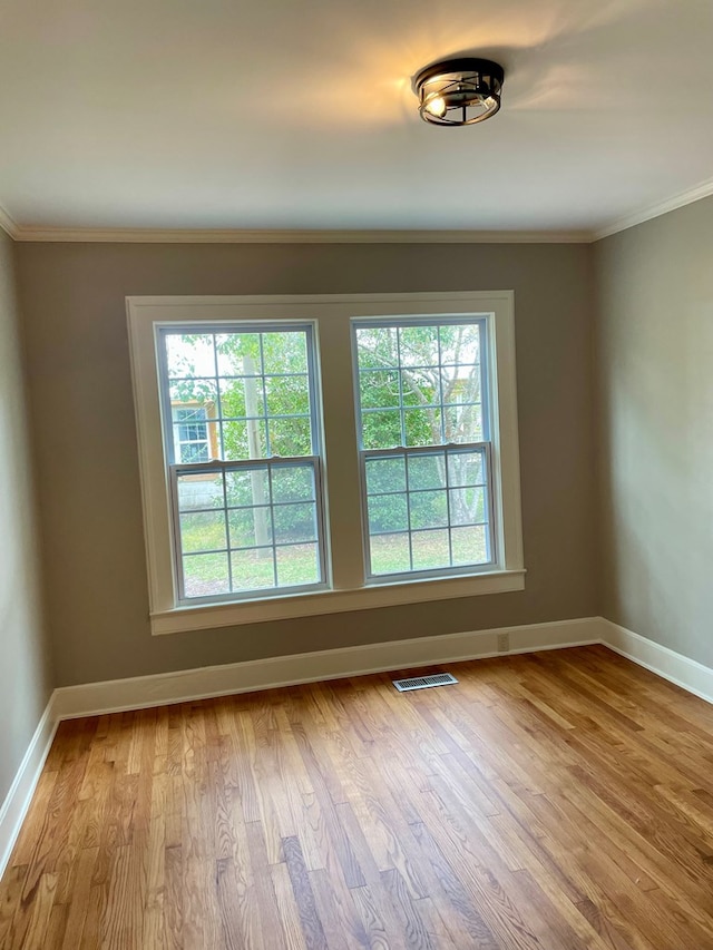 unfurnished room with light hardwood / wood-style flooring, plenty of natural light, and ornamental molding