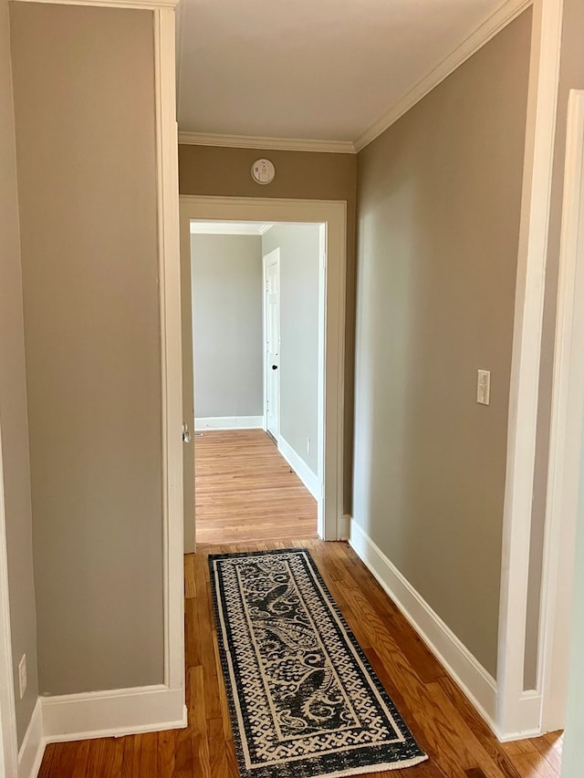 hall with hardwood / wood-style flooring and ornamental molding