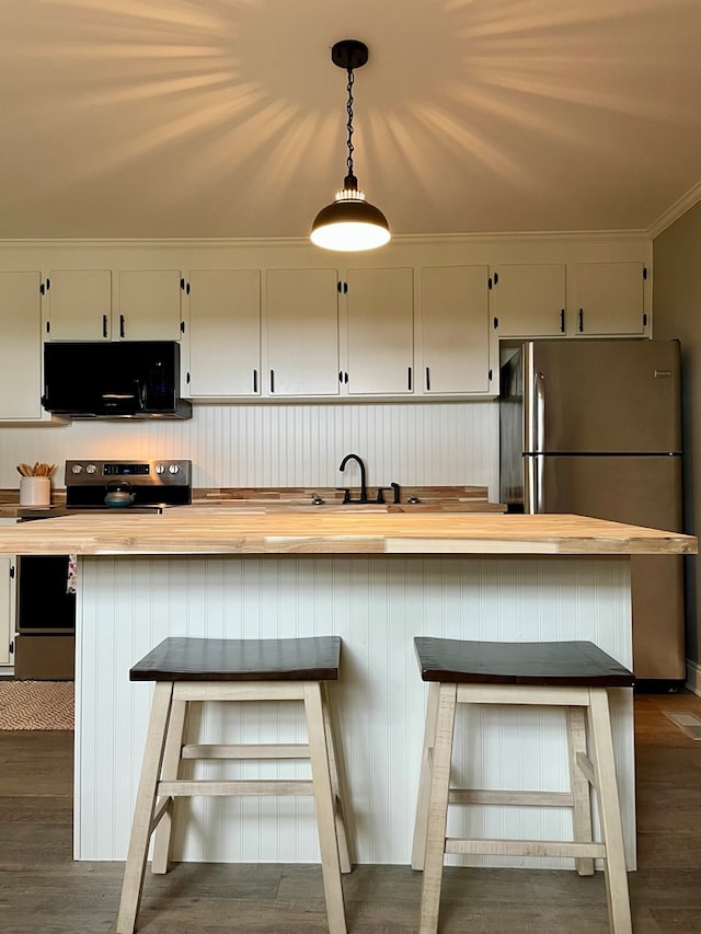 kitchen featuring a kitchen bar, dark hardwood / wood-style flooring, stainless steel appliances, pendant lighting, and white cabinetry