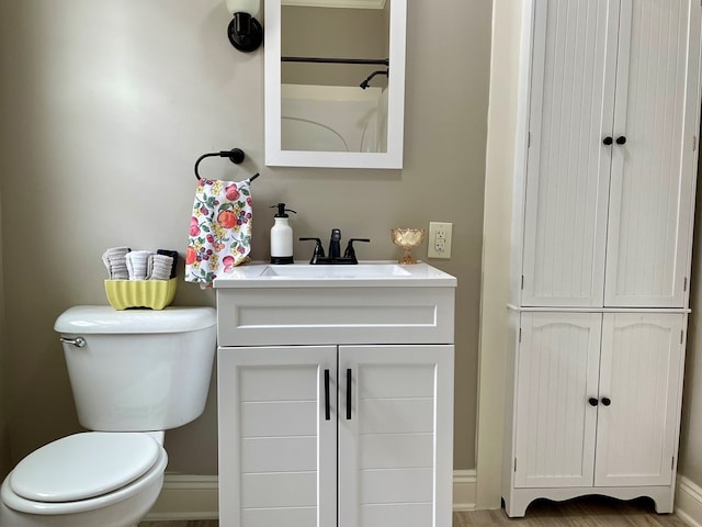 bathroom featuring vanity, hardwood / wood-style flooring, and toilet