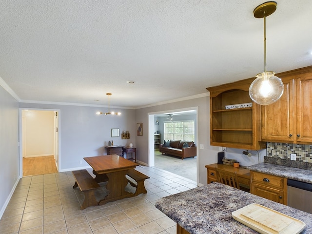 dining room with light tile patterned floors, a textured ceiling, baseboards, and crown molding