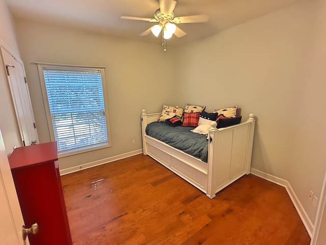 bedroom featuring a ceiling fan, baseboards, and wood finished floors