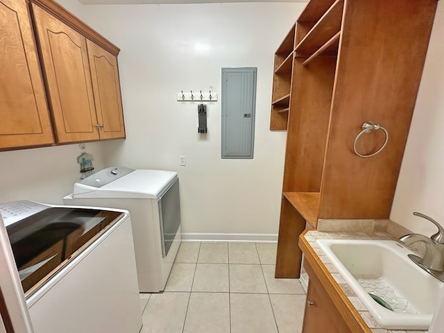 laundry room featuring washing machine and clothes dryer, electric panel, light tile patterned floors, cabinet space, and a sink