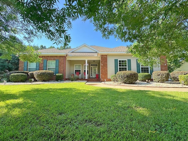 single story home with a front yard, a porch, and brick siding