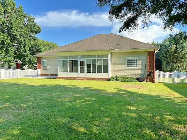 back of property with a yard, fence private yard, and a sunroom