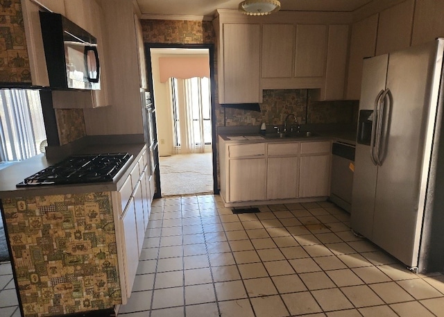 kitchen with appliances with stainless steel finishes, crown molding, a healthy amount of sunlight, and sink