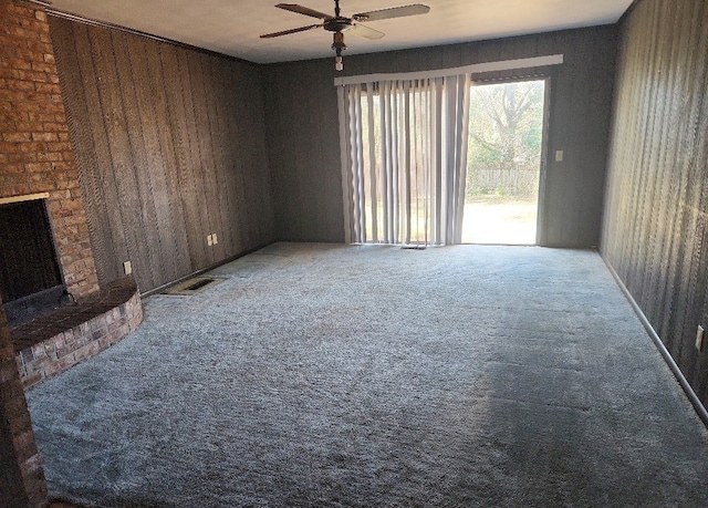 unfurnished living room with carpet flooring, ceiling fan, and a fireplace