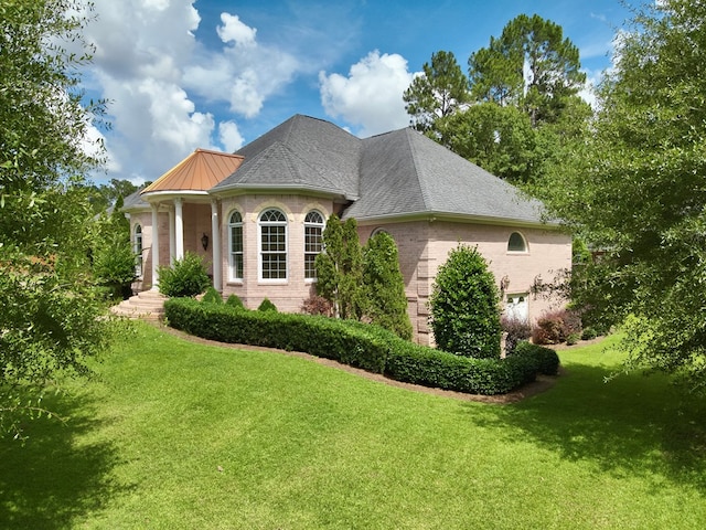 403 Stonegate Dr, Dothan, AL 36305 - view of side of home featuring a lawn, brick siding, a metal roof, and a garage