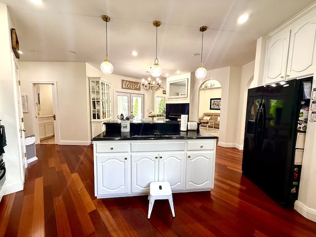 403 Stonegate Dr, Dothan, AL 36305 - kitchen with black refrigerator with ice dispenser, dark countertops, white cabinetry, dark wood finished floors, and a chandelier