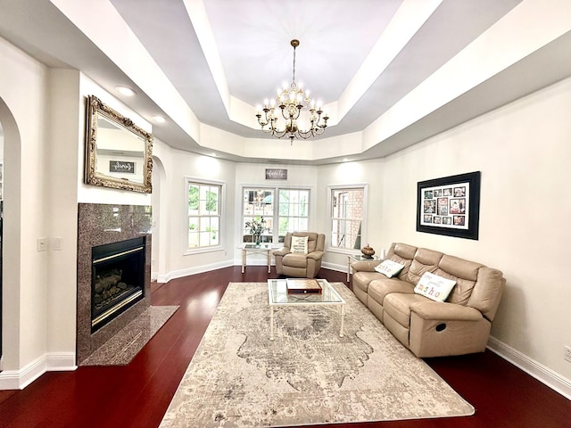403 Stonegate Dr, Dothan, AL 36305 - living area with arched walkways, a premium fireplace, a raised ceiling, a chandelier, and dark wood-style flooring
