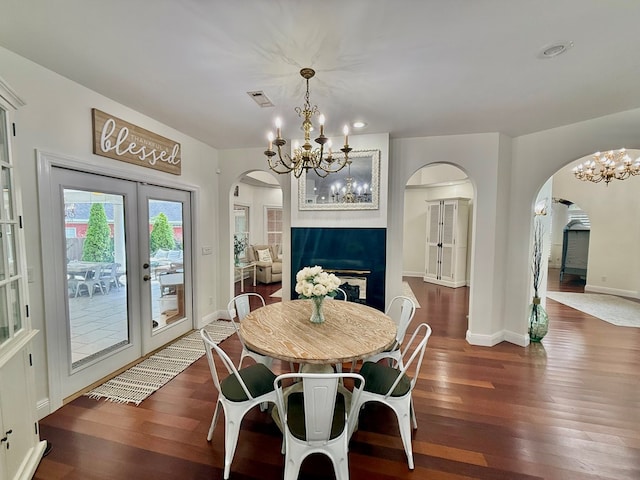 403 Stonegate Dr, Dothan, AL 36305 - dining room featuring arched walkways, a chandelier, hardwood / wood-style floors, a fireplace, and french doors