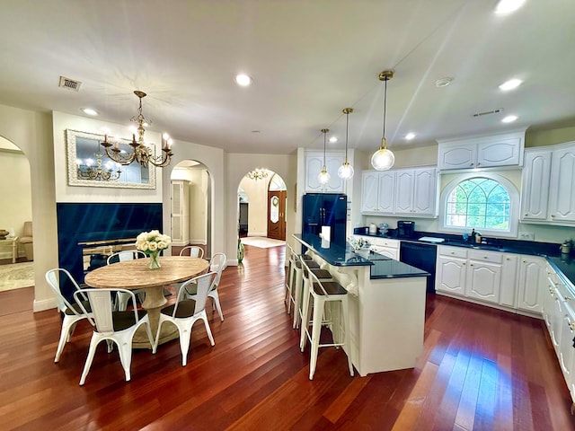 403 Stonegate Dr, Dothan, AL 36305 - kitchen with arched walkways, black appliances, dark countertops, dark wood-type flooring, and white cabinetry
