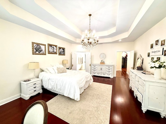 403 Stonegate Dr, Dothan, AL 36305 - bedroom with a chandelier, a tray ceiling, a walk in closet, dark wood-style flooring, and a closet