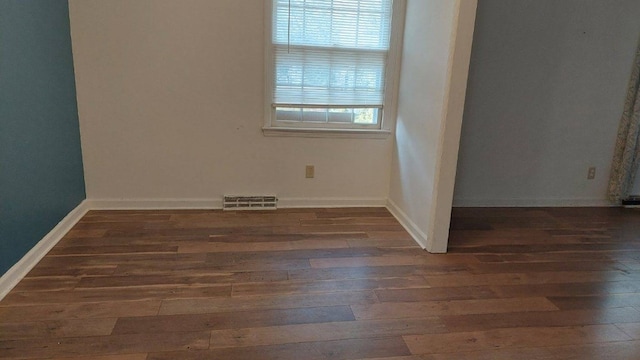 unfurnished room featuring hardwood / wood-style floors, baseboards, and visible vents