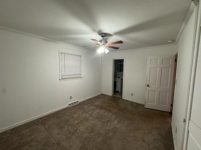 unfurnished bedroom featuring visible vents, dark carpet, baseboards, and crown molding