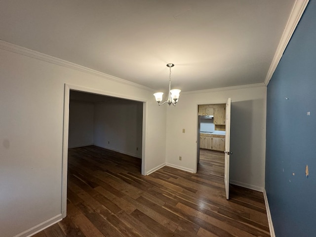 unfurnished dining area featuring dark wood finished floors, a chandelier, crown molding, and baseboards