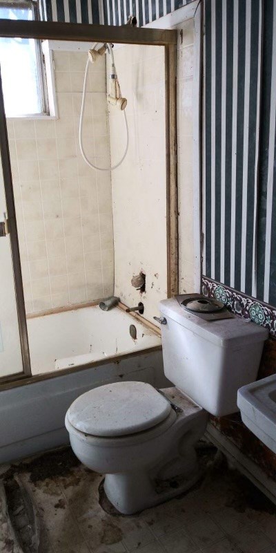 bathroom with tiled shower / bath combo and toilet