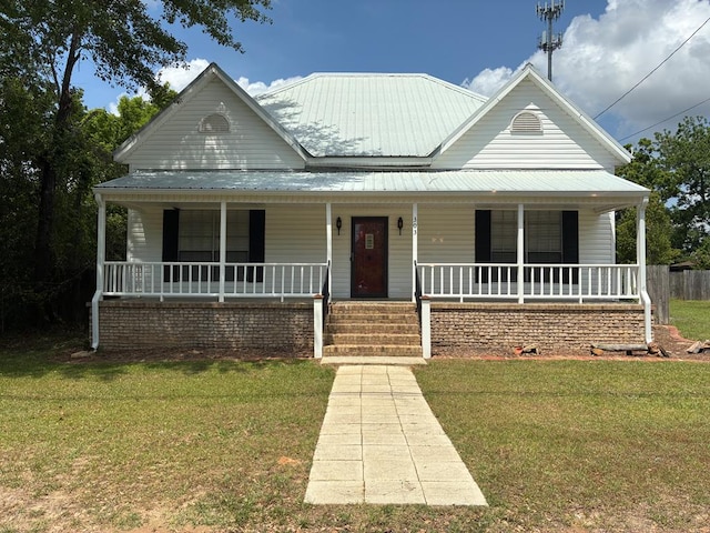 farmhouse-style home featuring a porch, a front lawn, and metal roof