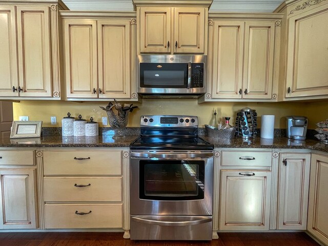 1621 Adkinson Rd, Newton, AL 36352 - kitchen featuring stainless steel appliances, cream cabinetry, dark stone countertops, and dark wood-type flooring