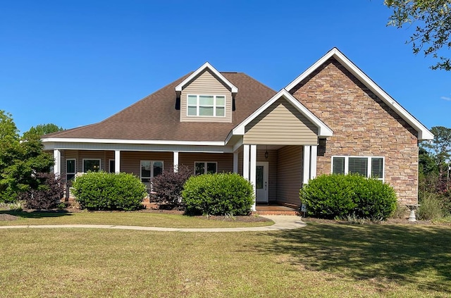 craftsman-style home featuring a front lawn, covered porch, and stone siding